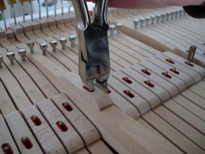 Pinçage des mortaises sur un piano à queue